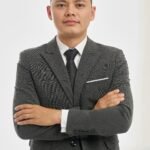 Home Portrait of a confident businessman in a formal suit with arms crossed, isolated on white background.